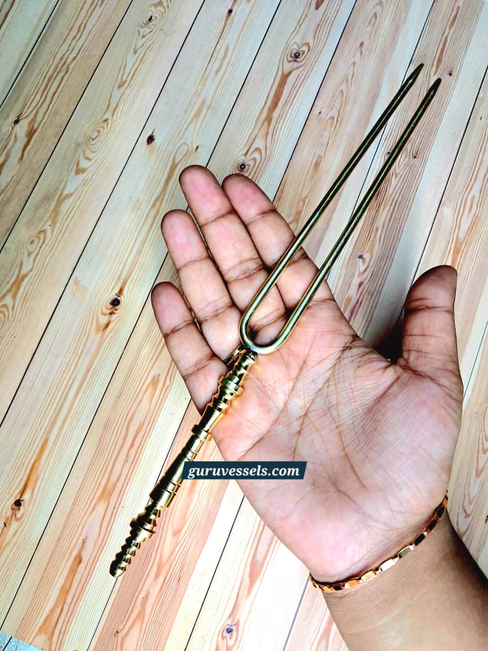 Authentic pure brass hair detangler held in hand from another angle, showing the 10 inch size, detailed traditional handle and premium finish