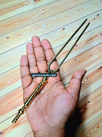 Original product photo of a premium pure brass hair detangler held in hand, showing its size, traditional handle and smooth detangling prongs